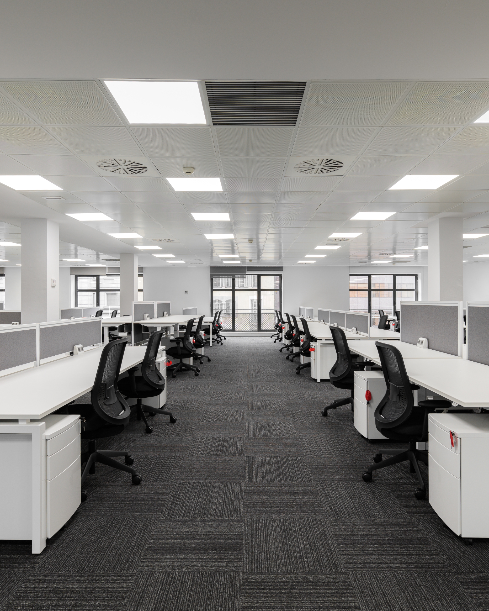 Empty open office space with modern design and ergonomic setup Construcción de Proyectos de Oficinas Guatemala